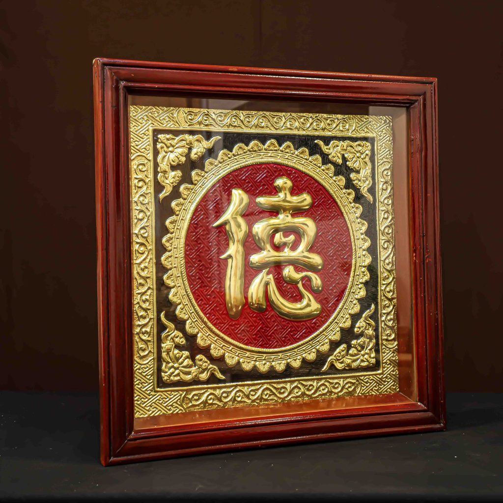 Bức tranh nổi bật với sự kết hợp hoàn mỹ giữa sắc vàng kim rực rỡ của chữ Đức bằng đồng và nền sơn đỏ thắm